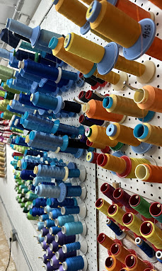 Wall of embroidery thread spools at our Hialeah shop.